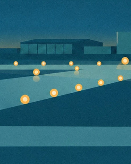 The yellow runway lights in front of the dark airport buildings