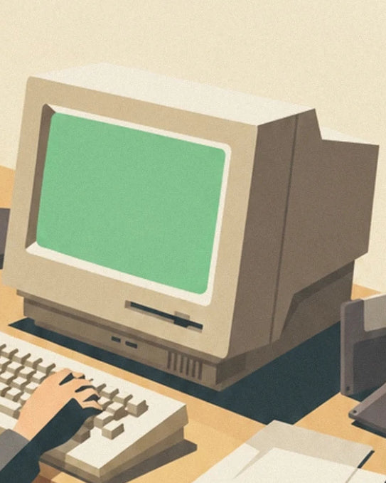 Der beige Computer mit seinem grünen Bildschirm und die Tastatur unter der Hand des Nutzers