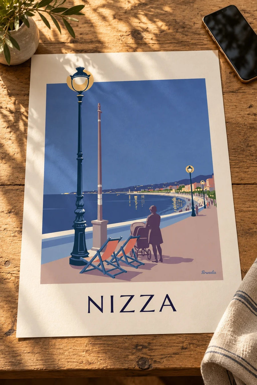 Poster Liegestühle und Laterne an der Baie des Anges am Abend: auf einem Tisch abgestellt