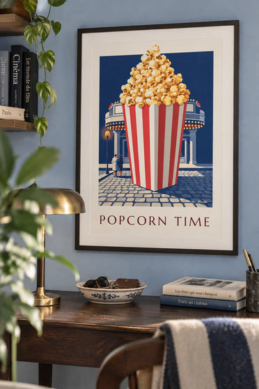 Affiche seau de pop-corn chaud rayé rouge et blanc devant le cinéma : encadrée au mur