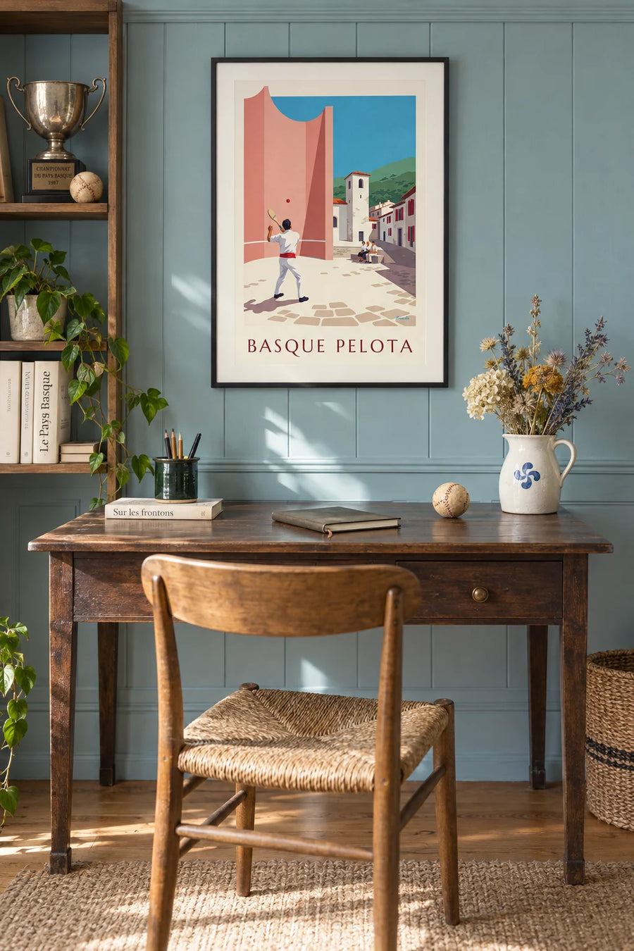 Poster of a pelota player in front of the village fronton: framed on the wall